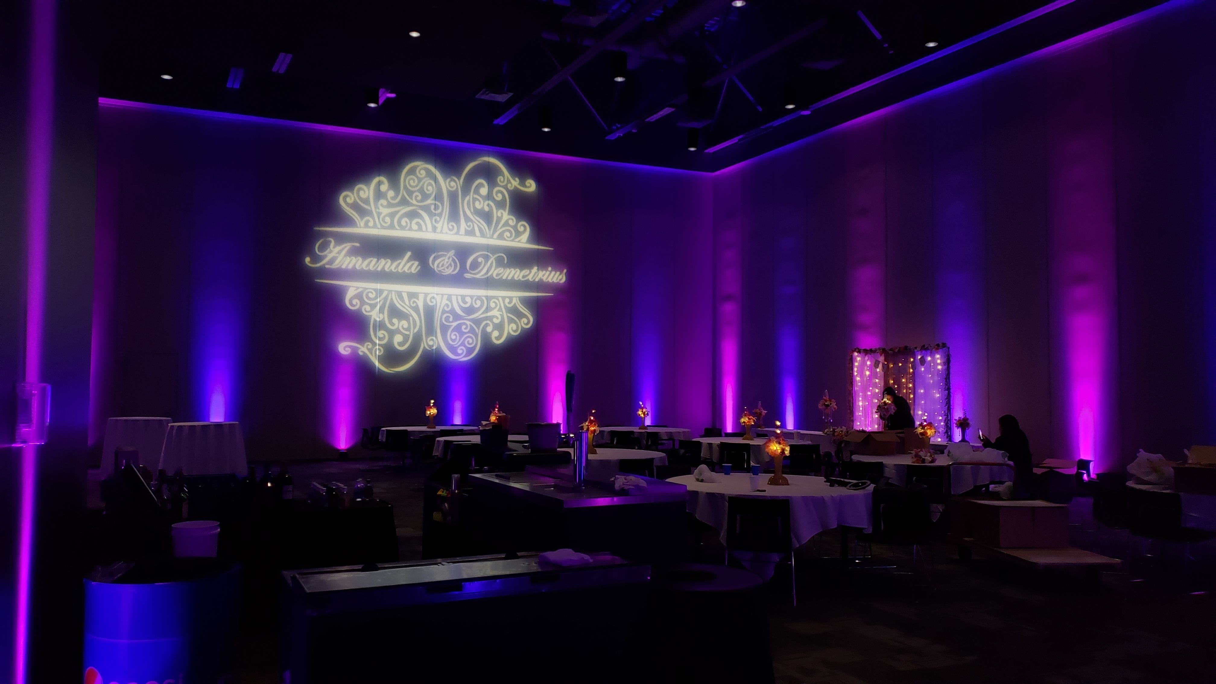 Wedding Lighting at Black Bear Casino, Otter Creek Convention Center. Up lighting in magenta and purple with wedding monogram.