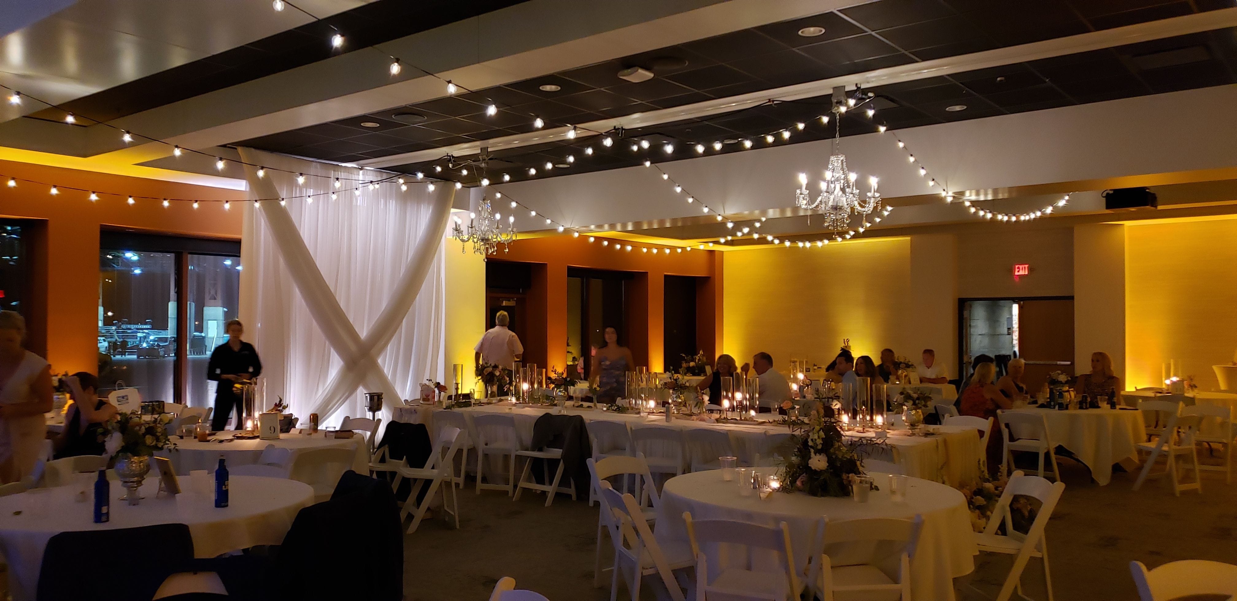 Wedding lighting at Pier B. Up lighting in amber with bistro and chandeliers.