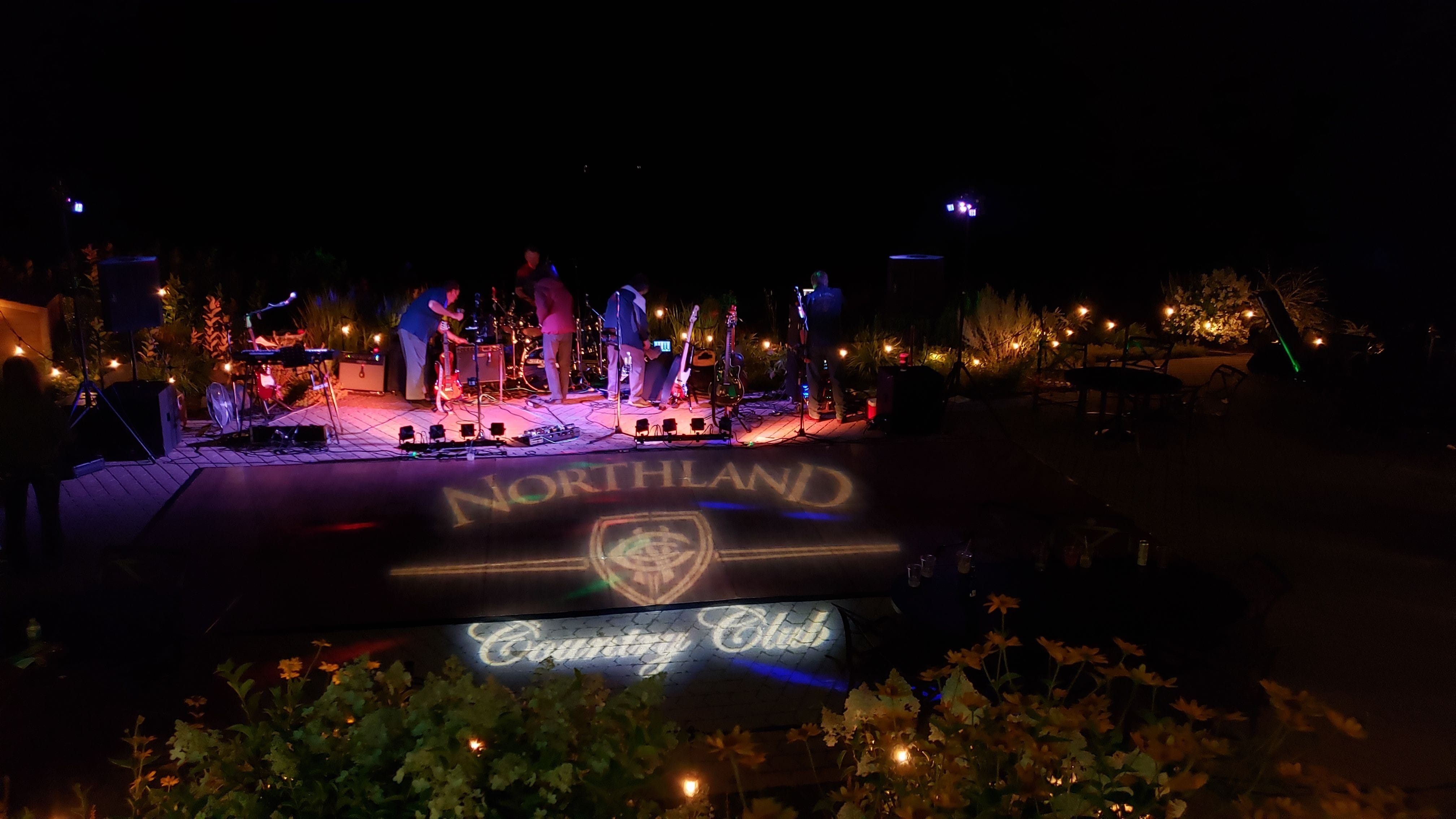 Northland Country Club logo on the dance floor with garden bistro lighting up the area.