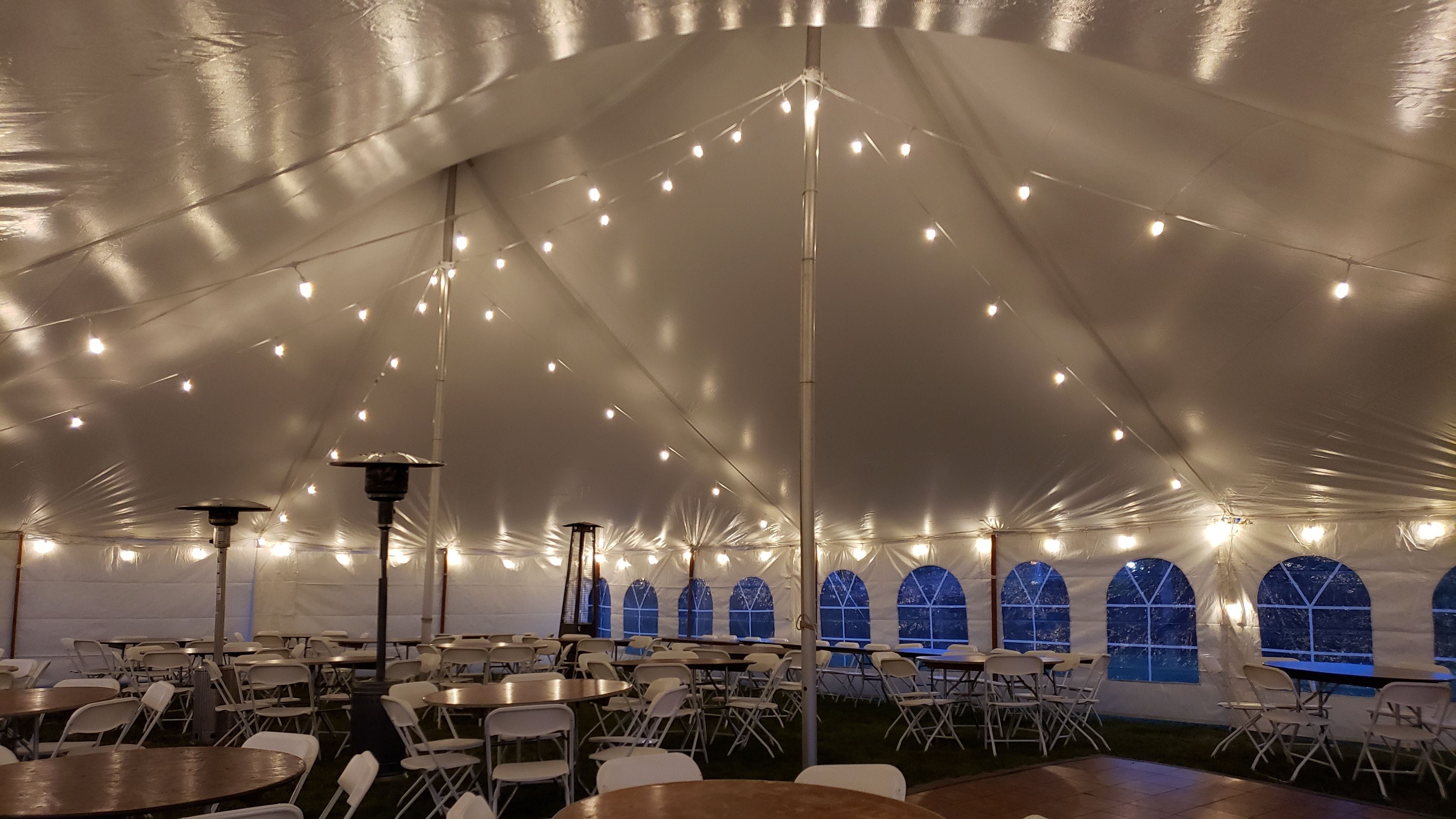 Tent wedding lighting. White cord bistro on dimmers inside a tent for a wedding.