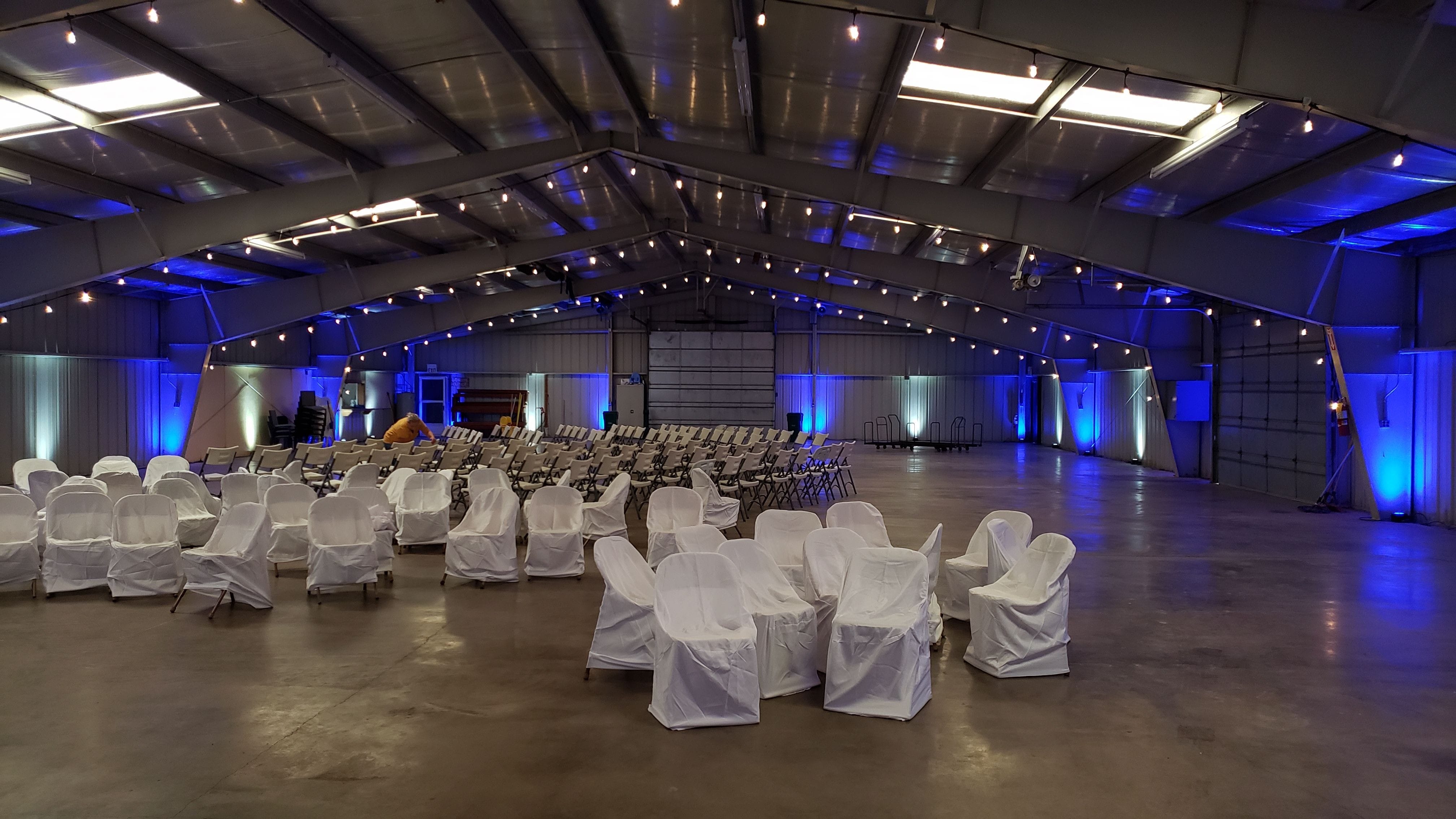 Lake County Fairgrounds wedding lighting in blue and white up lighting with bistro on the beams by Duluth Event Lighting.