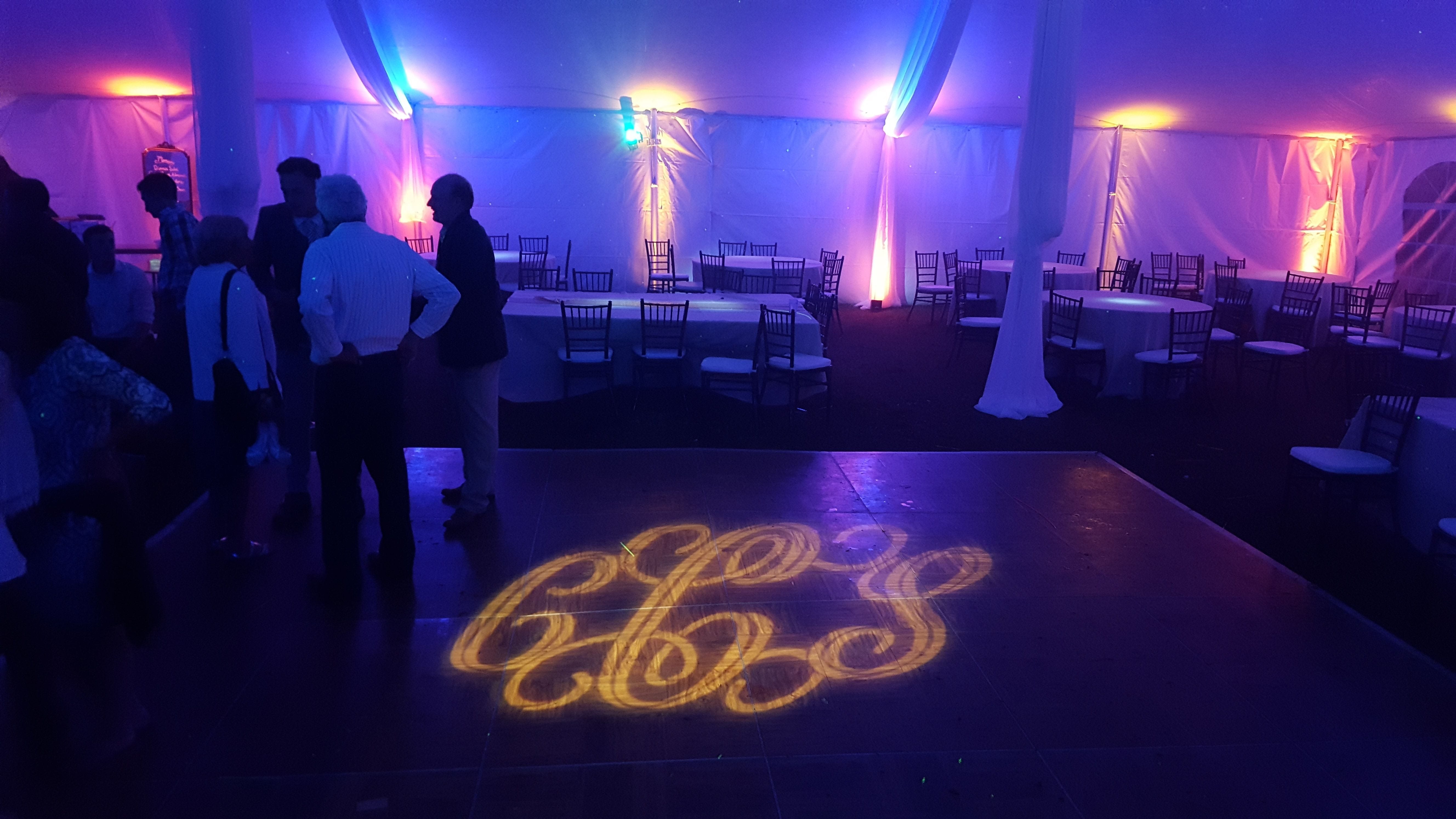 Tent wedding lighting. Up lighting in blue and orange. Stars and Northern Lights on the ceiling. Pin spots on flowers. Decor by @thevaultduluth