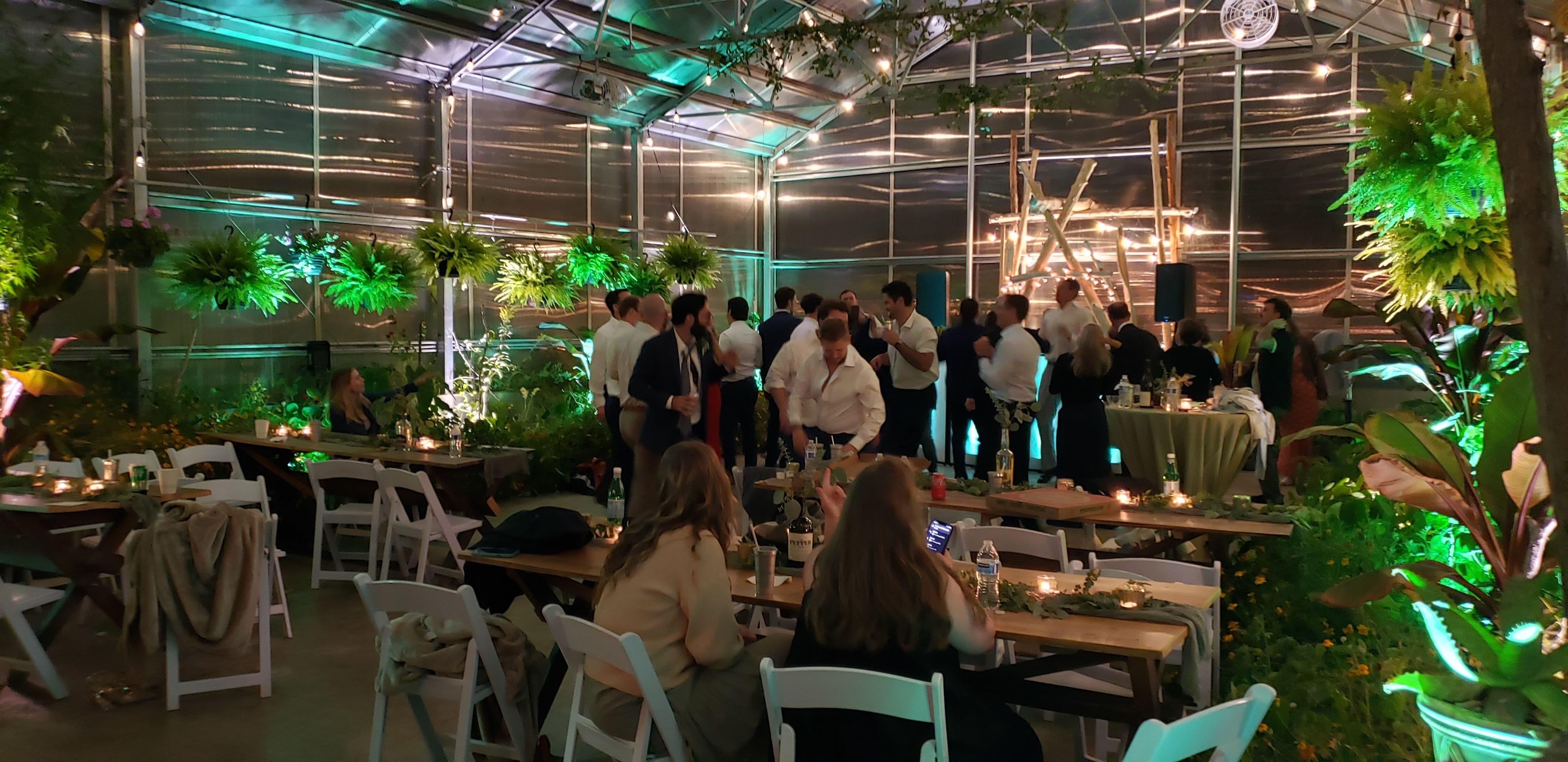 Wedding lighting with Mint green and soft white up lighting inside the greenhouse of Sitio Events