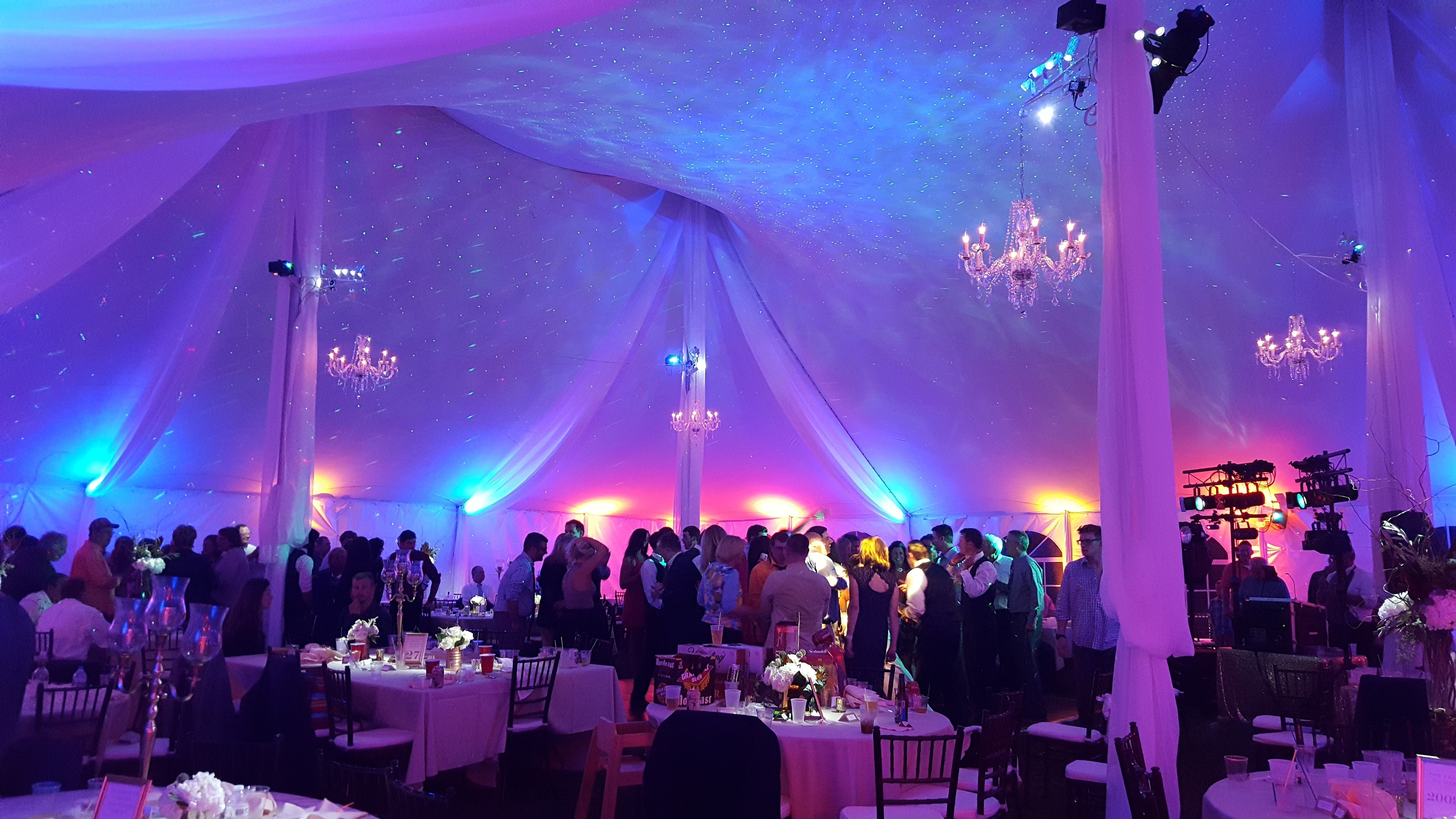 Wedding lighting in a tent with up lighting and chandeliers by Duluth Event Lighting.