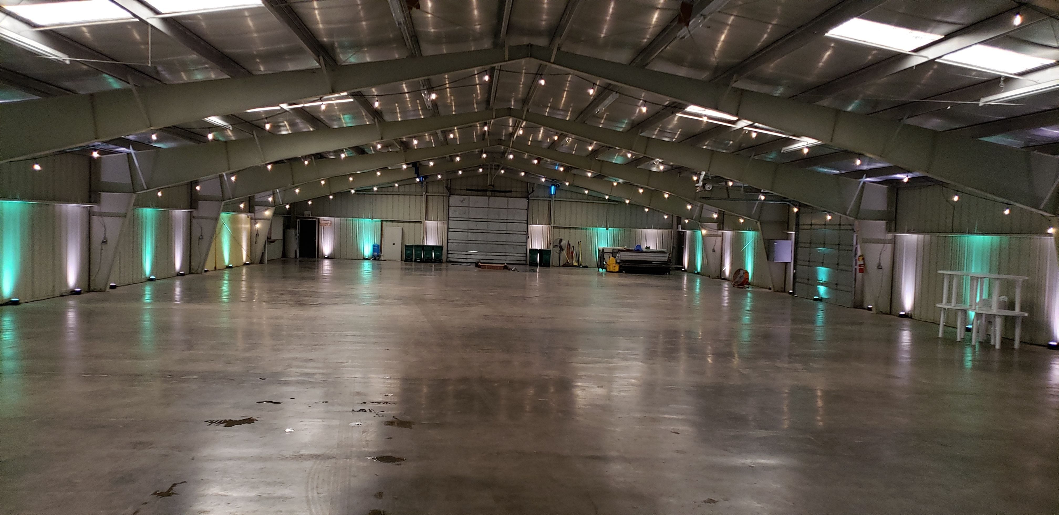 Wedding lighting at the Lake County Fairgrounds with mint green and soft white up lighting and bistro on the beams by Duluth Event Lighting