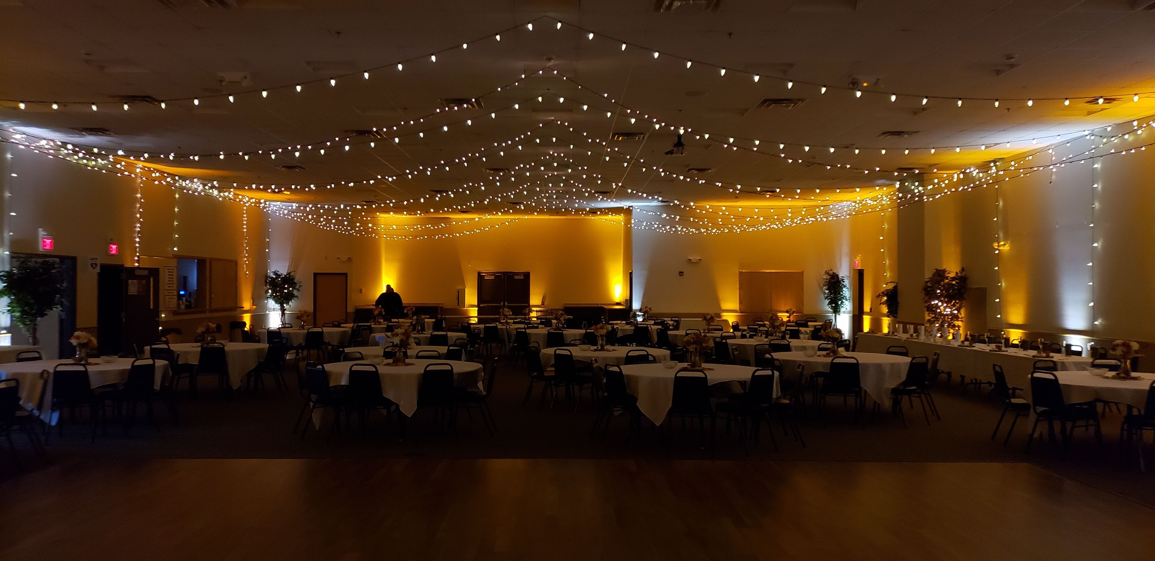 wedding lighting at the AAD Shrine with soft gold and white up lighting with double thick bistro on the ceiling.