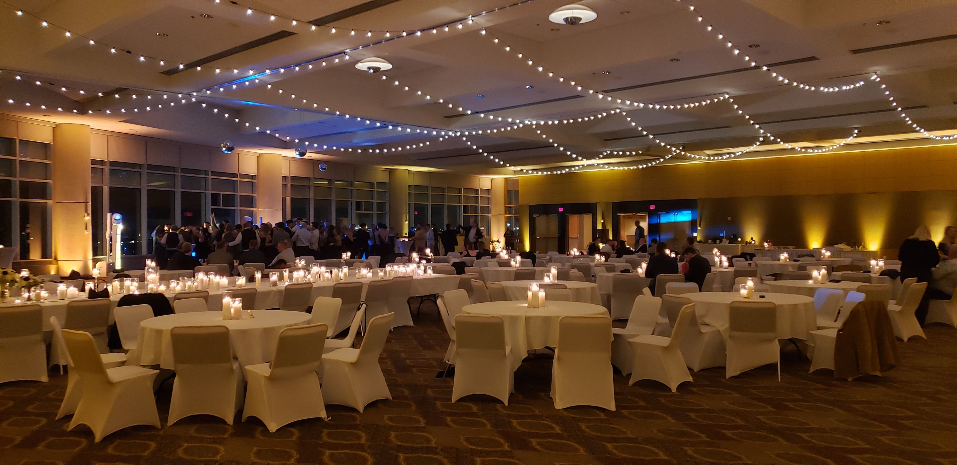 Wedding lighting in the Harbor Side Ballroom at the DECC. Up lighting in soft gold with bistro by Duluth Event Lighting.