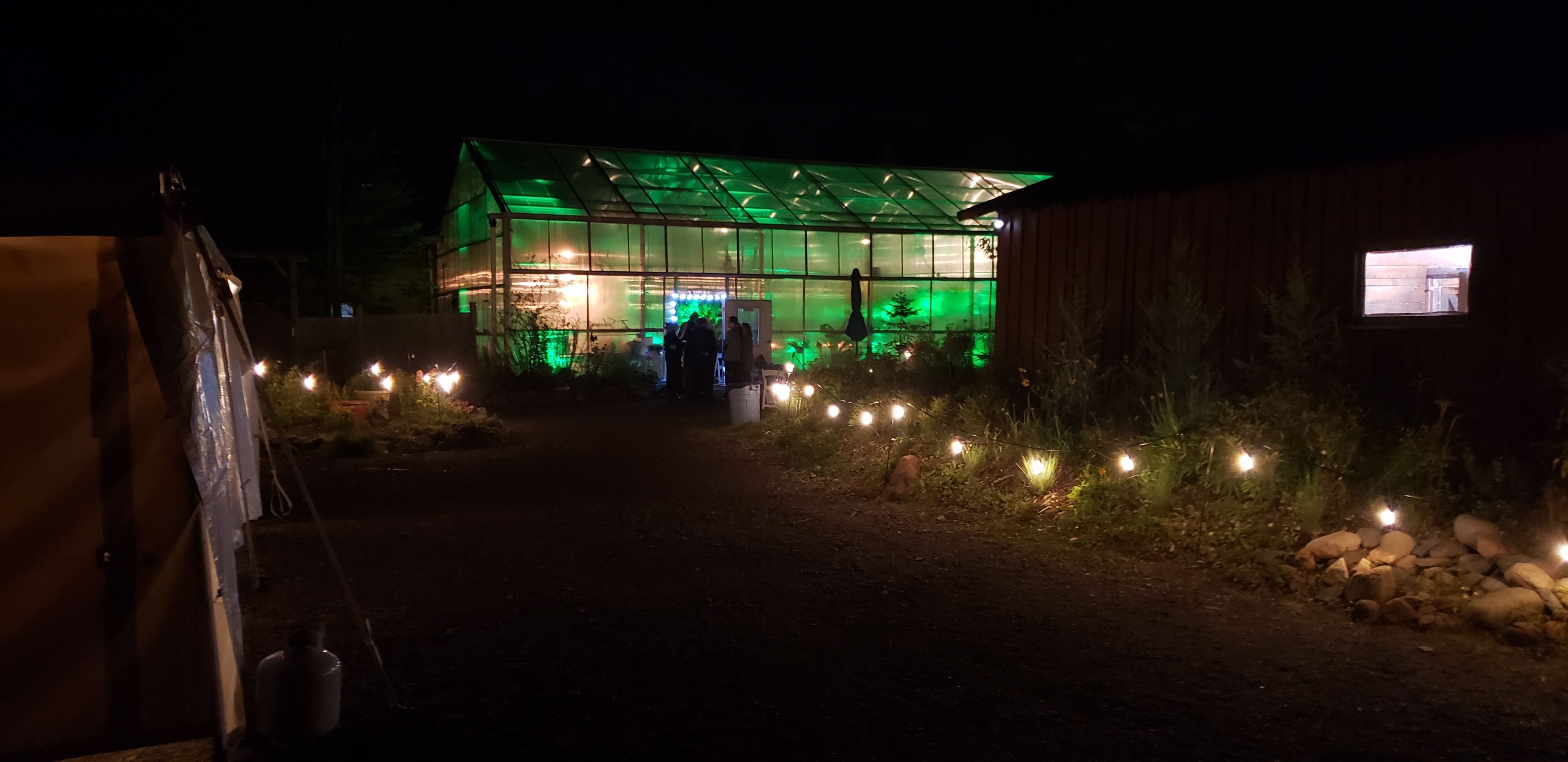 Garden bistro at Sitio with the greenhouse having green up lighting