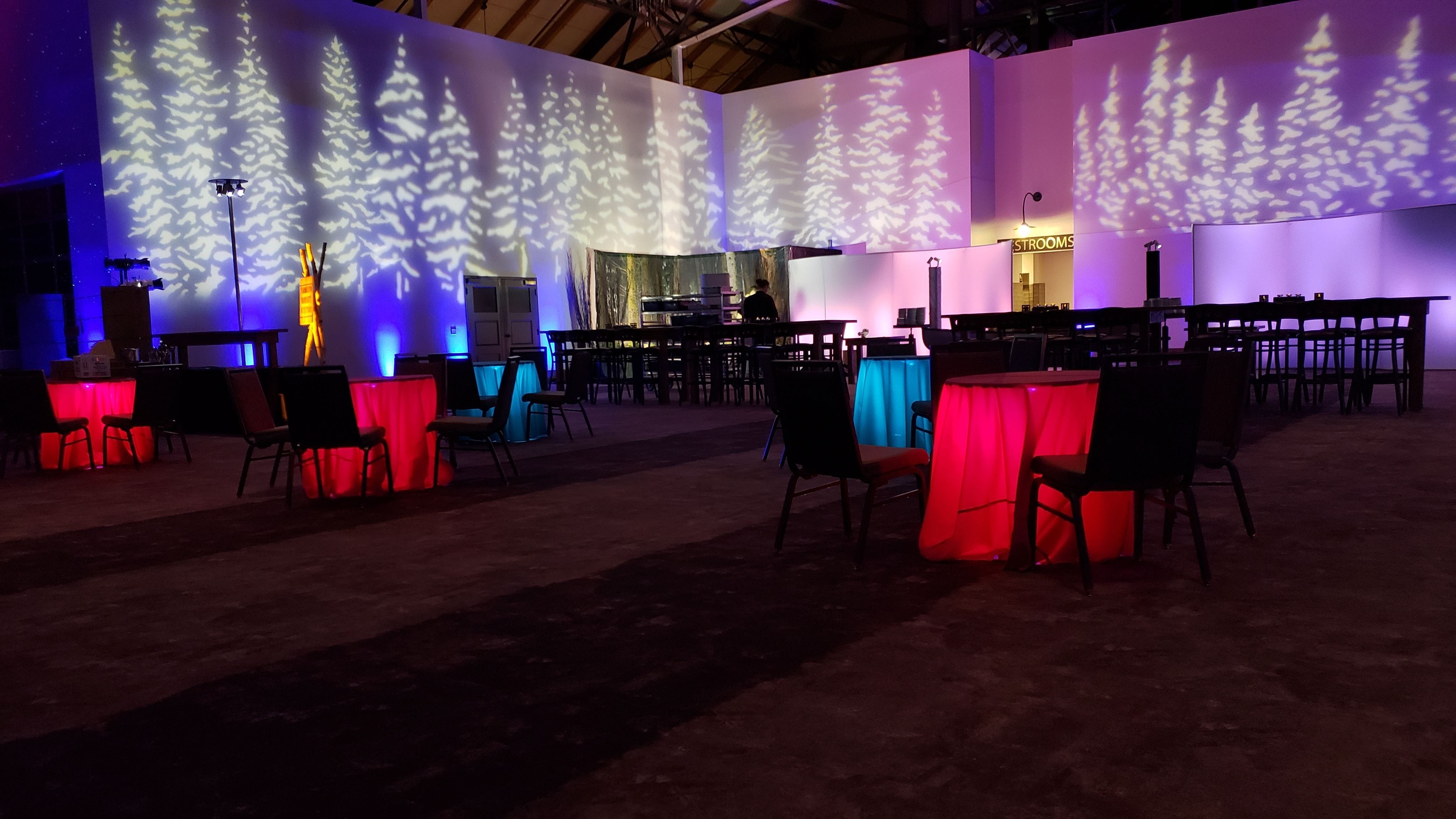 Northern Lights Themed party with tree gobos, glowing cocktail tables, and Stars and Northern Lights on the ceiling. Duluth Event Lighting