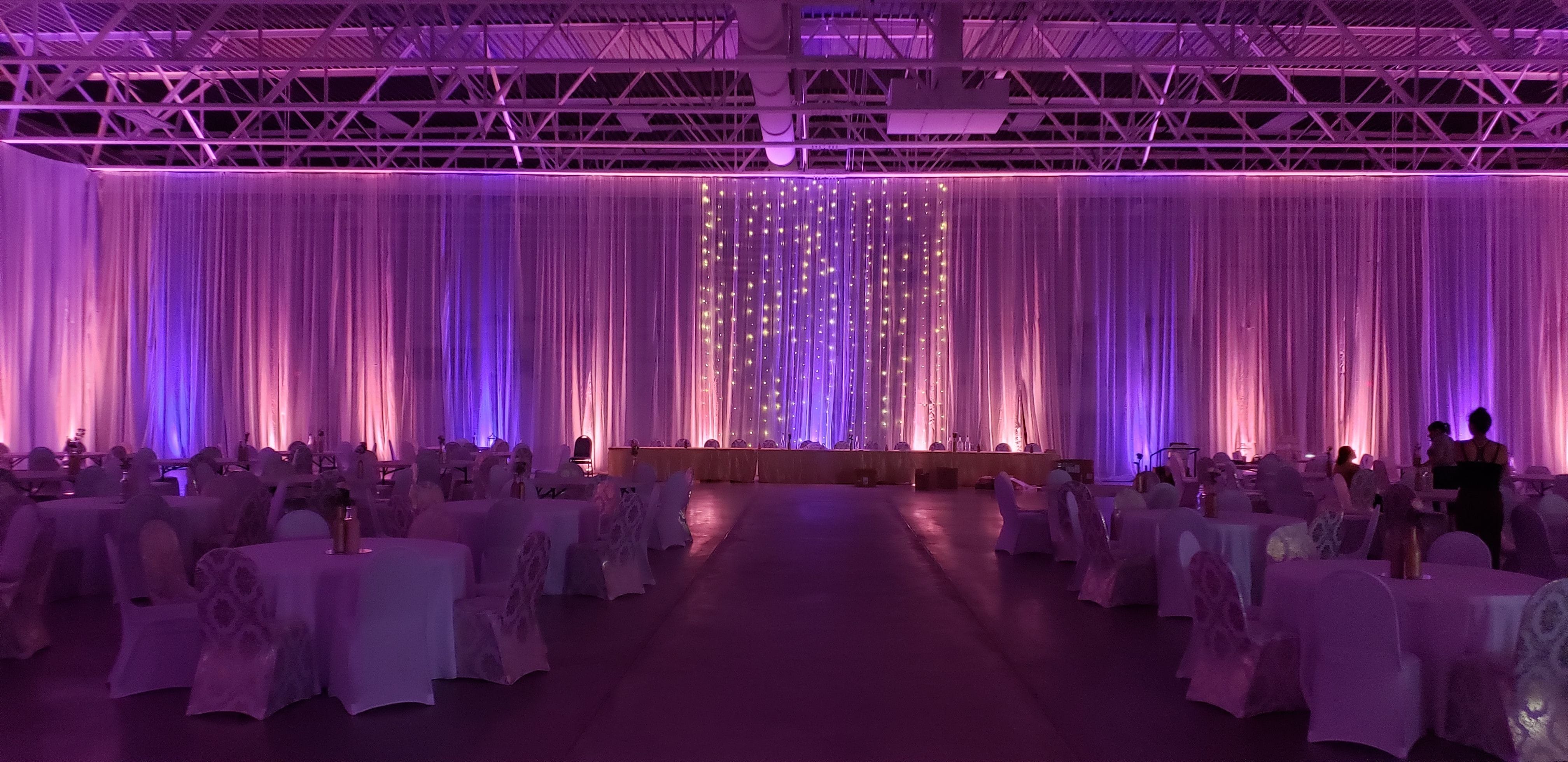 Wedding lighting at the Eveleth Curling club with peach and blue lavender up lighting.