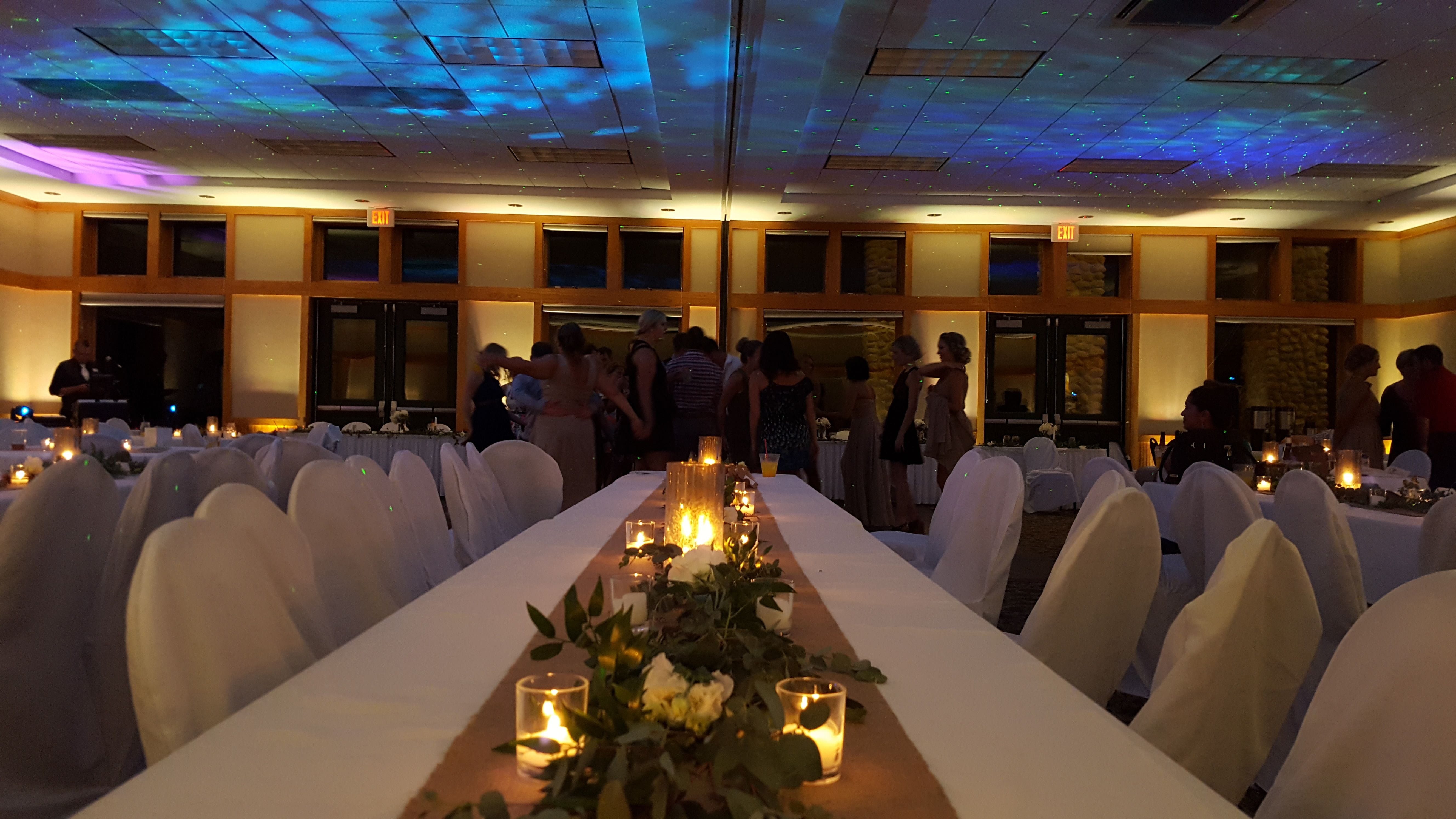 Wedding lighting at Heartwood Event Center in Trego. Up lighting in soft gold with stars and Northern Lights on the ceiling.
