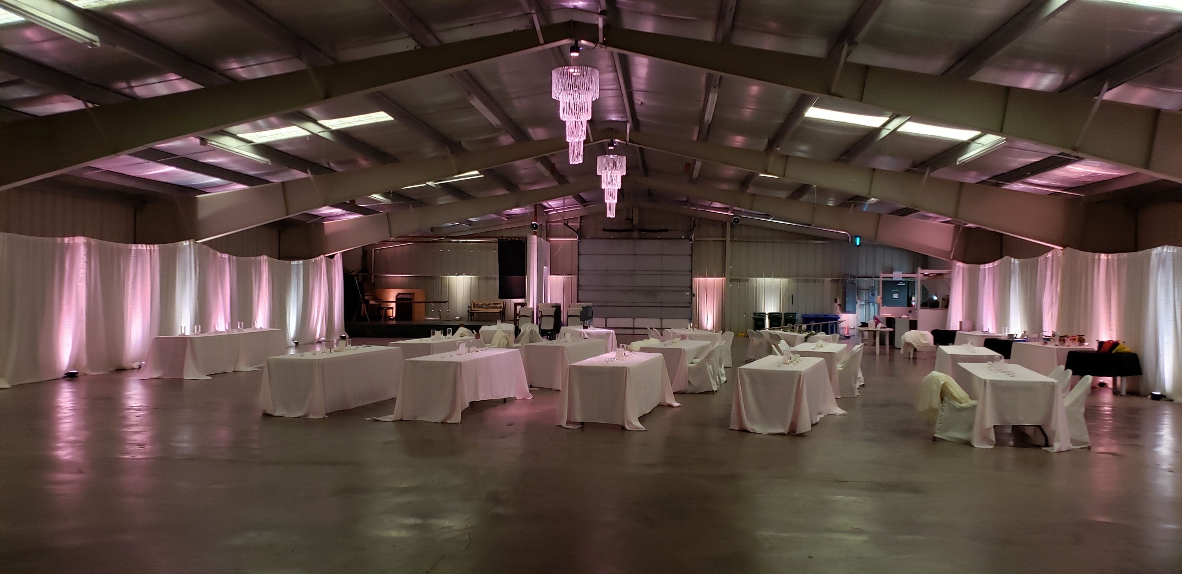 Wedding with blush pink and soft white up lighting and chandeliersby Duluth Event Lighting. at the Lake County Fairgrounds.