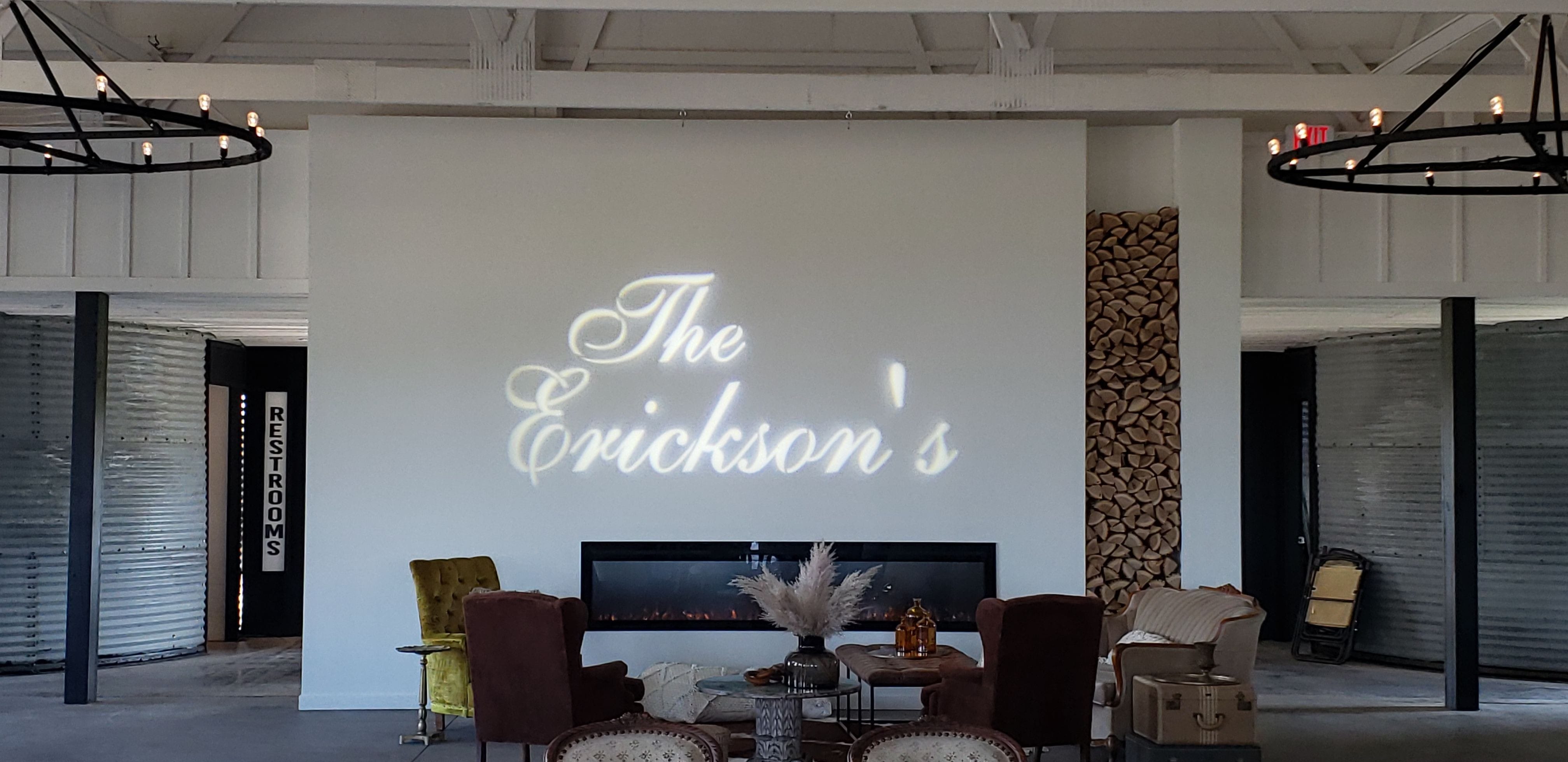 A wedding monogram is projected over thefireplace by Duluth Event Lighting