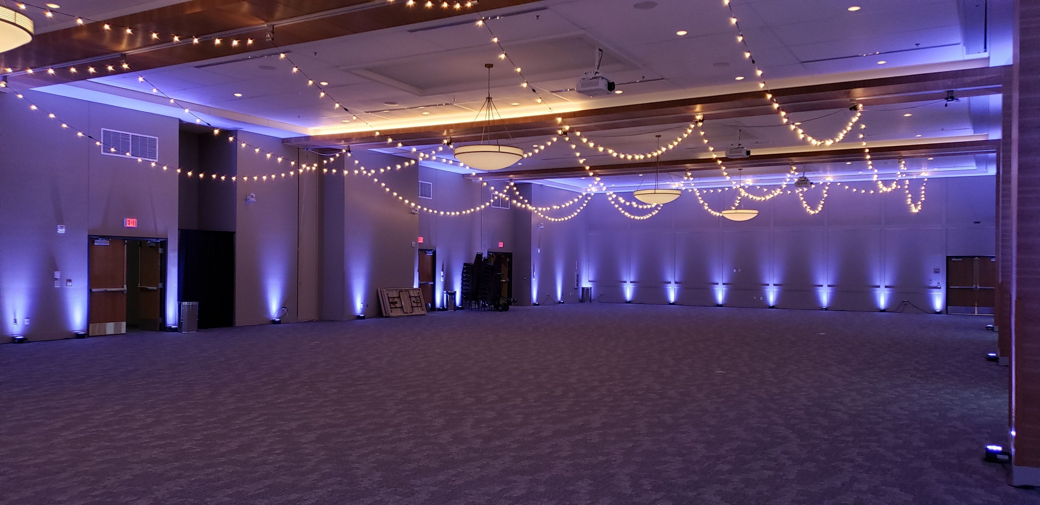 Iron Trail Motors Event Center wedding lighting in dusty blue up lighting and bistro on the ceiling by Duluth Event Lighting.