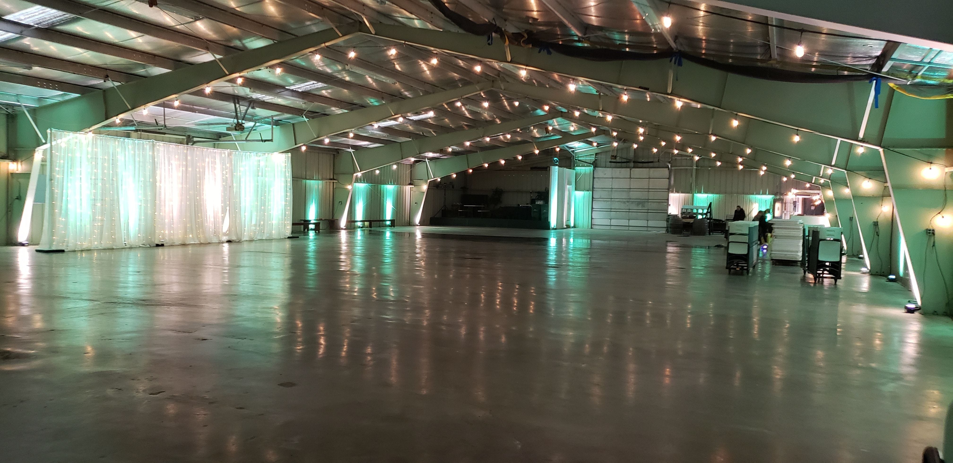 Wedding lighting at the Lakes County Fairgrounds. Up lighting in mint green and white with a head table backdrop by Duluth Event Lighting.