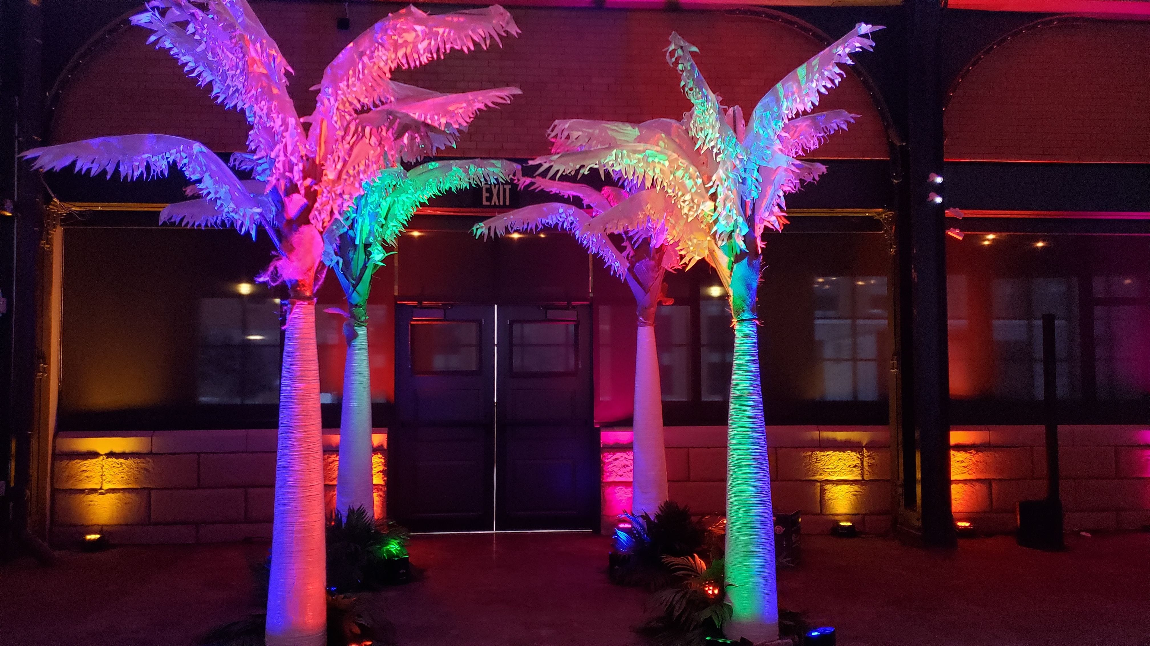 Beach Themed party lighting with palm trees with colorful up lighting by Duluth Event Lighting.