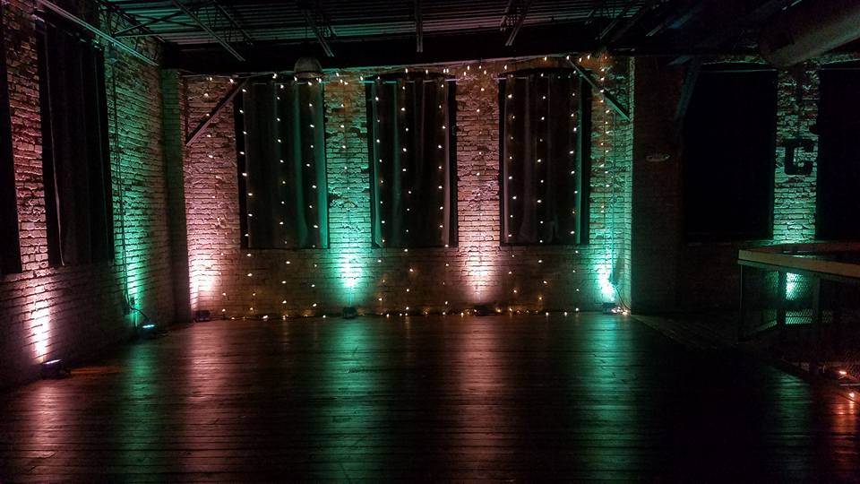 Wedding lighting with bistro on a brick wall as a wedding backdrop.