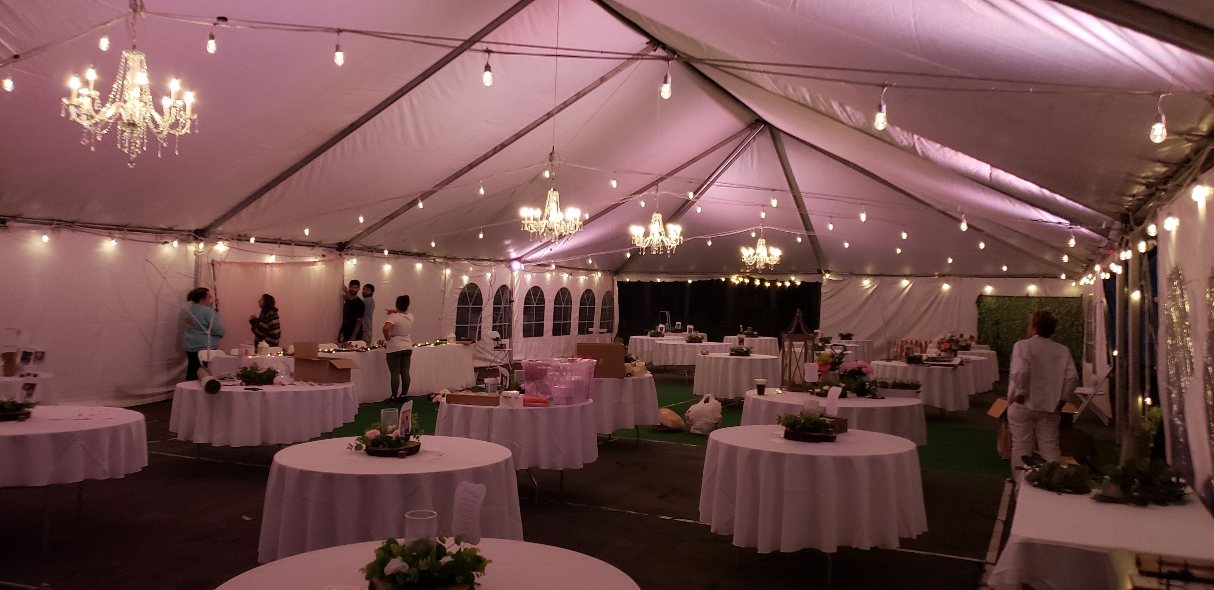 Tent wedding lighting. Up lighting in pink with chandeliers and bistro.