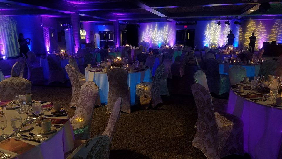 Northern Lights theme lighting. Up lighting in blues and purples with pine tree gobos. decor by Northland Special Events.